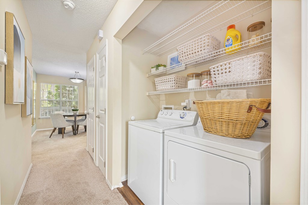 a laundry room with a washer and dryer and a door to a kitchen