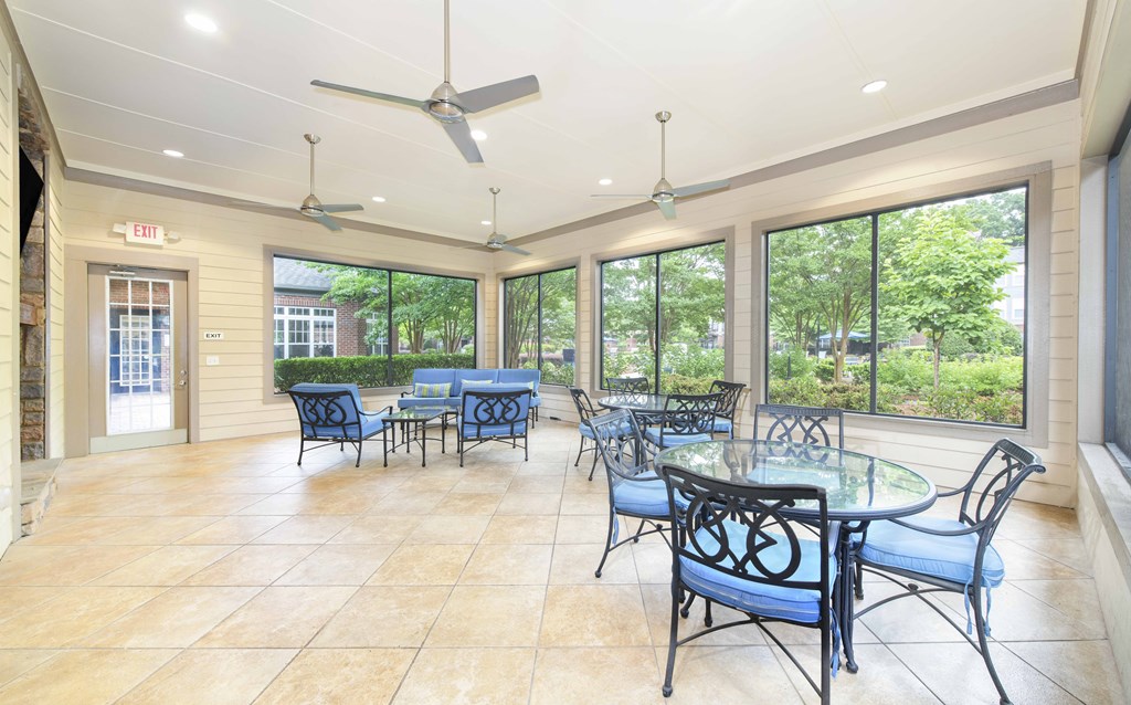 A patio with a glass table and chairs.
