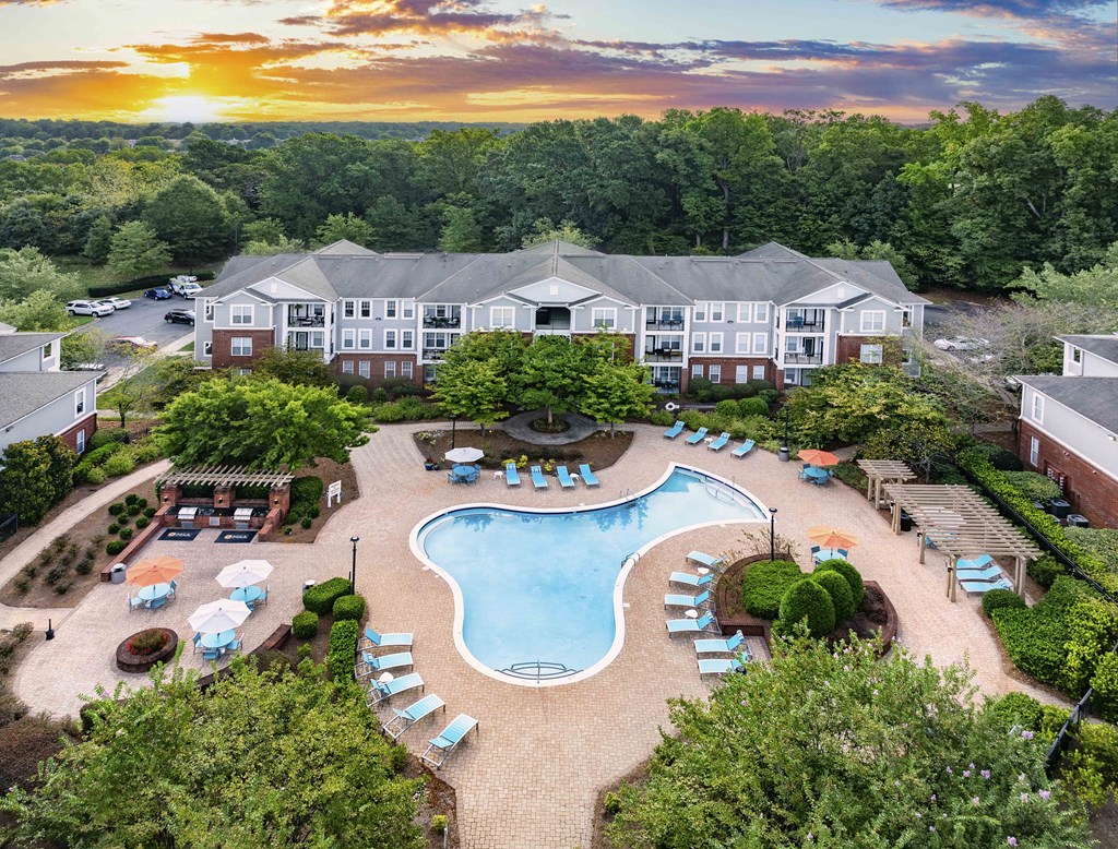 A large building with a pool in the middle of a grassy area.