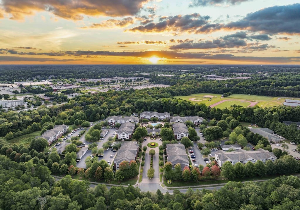 A sunset view of a residential area with houses and trees.