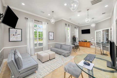 A modern living room with a grey sofa set, a glass coffee table, and a television.