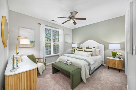 A bedroom with a large bed and a green bench.