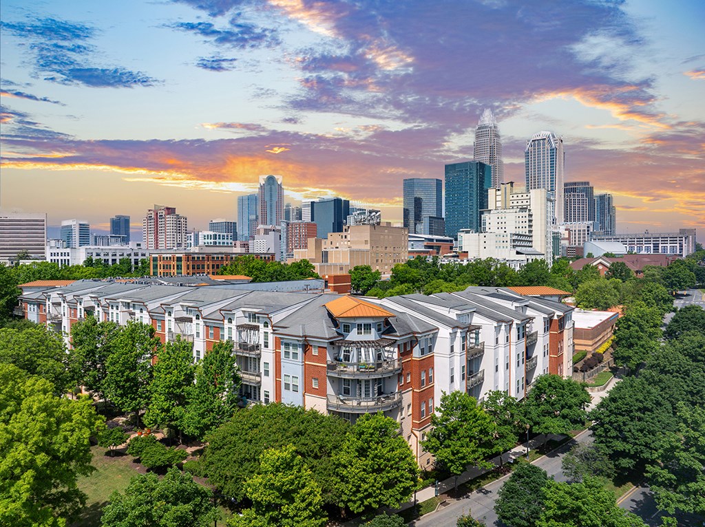 A cityscape with a large building in the foreground and a skyline in the background.