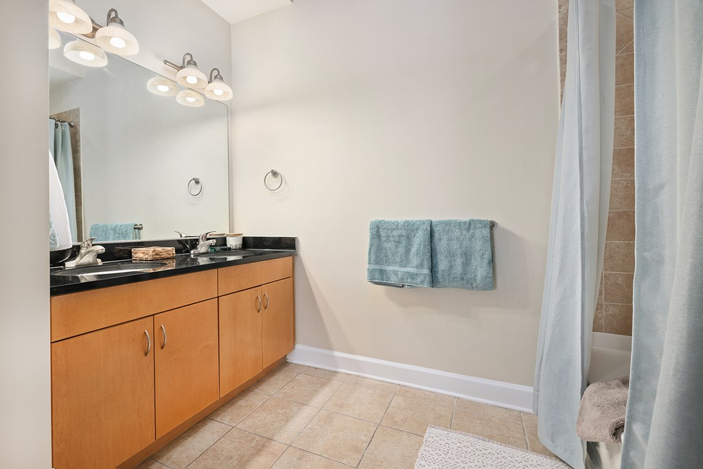 A bathroom with a sink, mirror, and towel rack.
