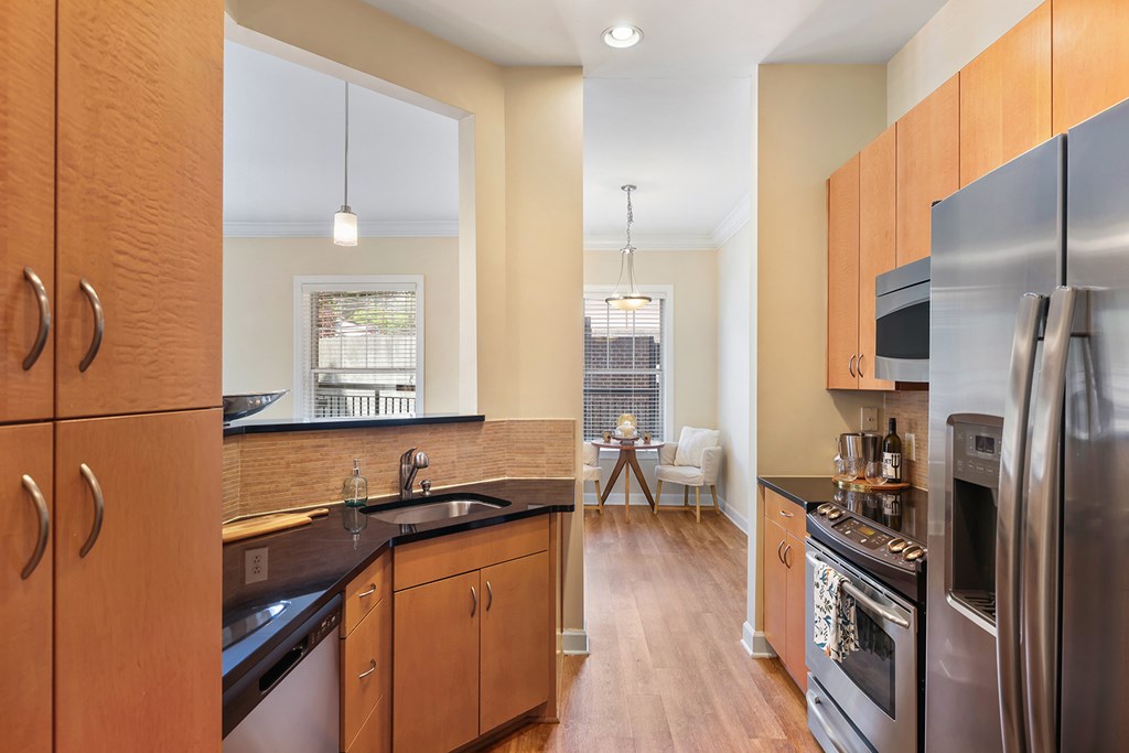 A kitchen with wooden cabinets and a black counter top.