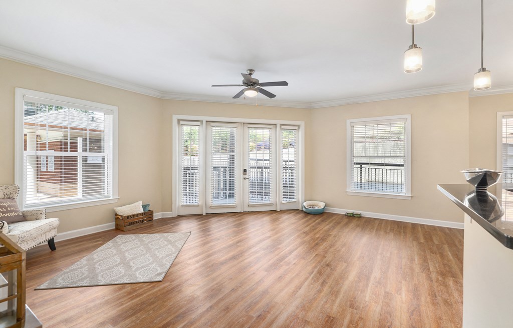 A living room with a ceiling fan and sliding glass doors.
