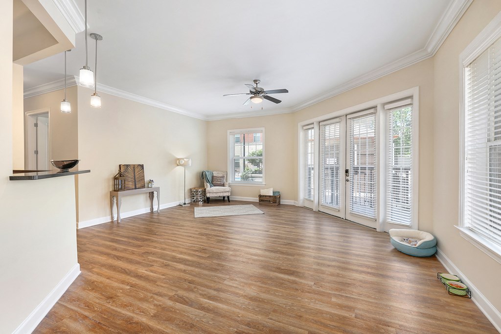 A spacious living room with hardwood floors and a ceiling fan.