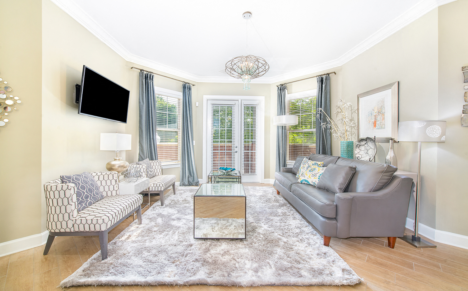 a living room with a couch and two chairs and a tv