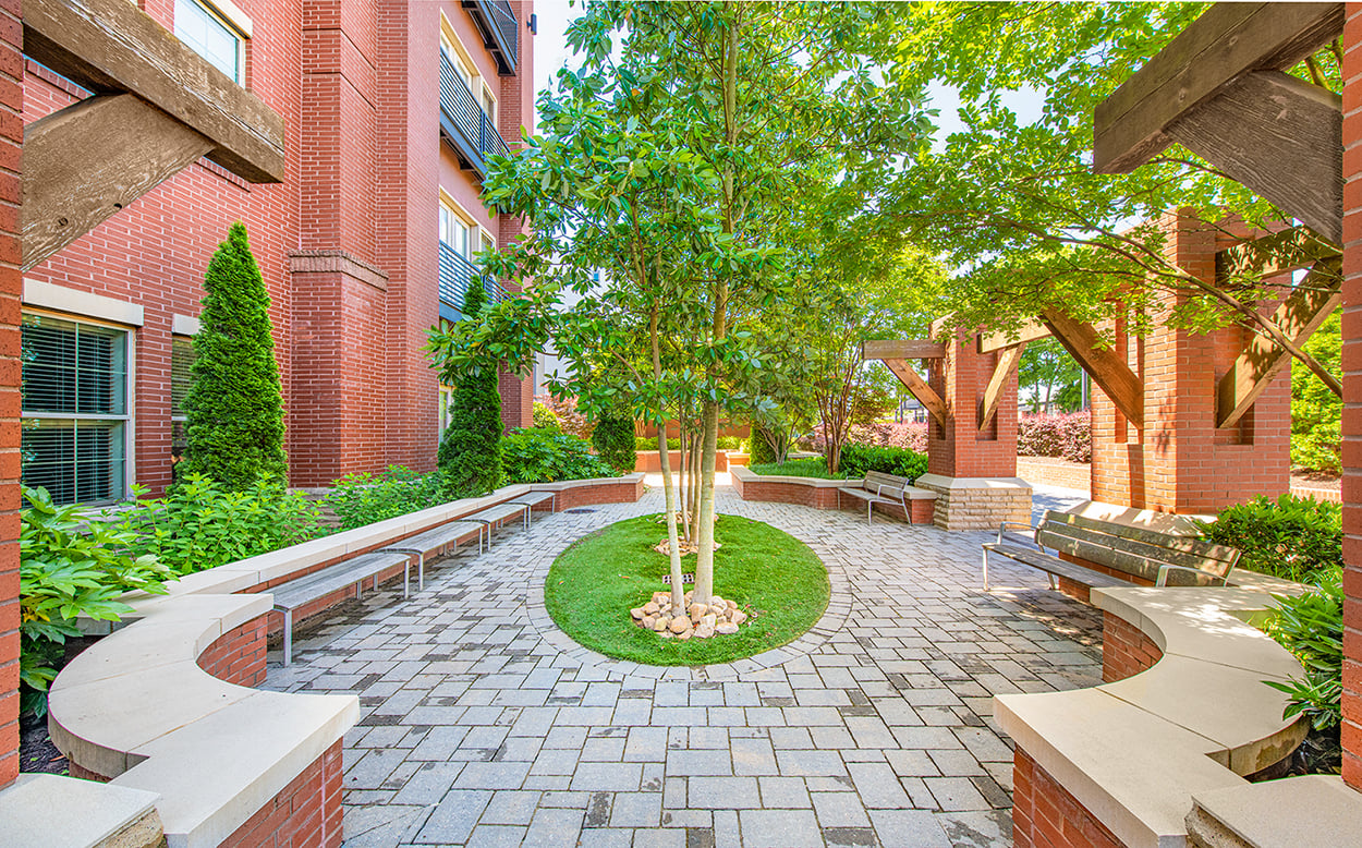a courtyard with benches and a tree in the middle of a building
