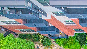 an aerial view of a swimming pool in front of an apartment building
