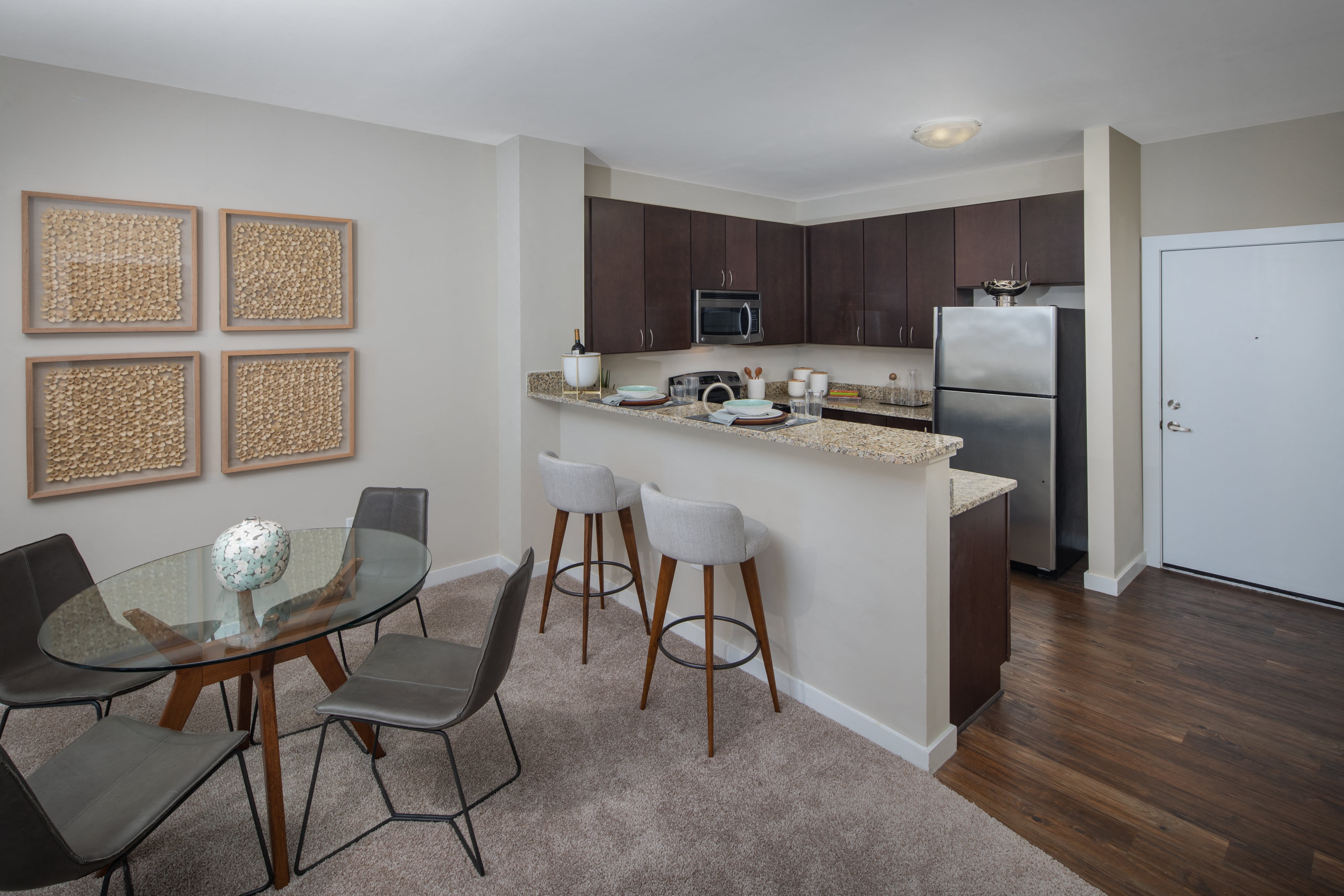 a kitchen and dining area with a table and chairs and a refrigerator