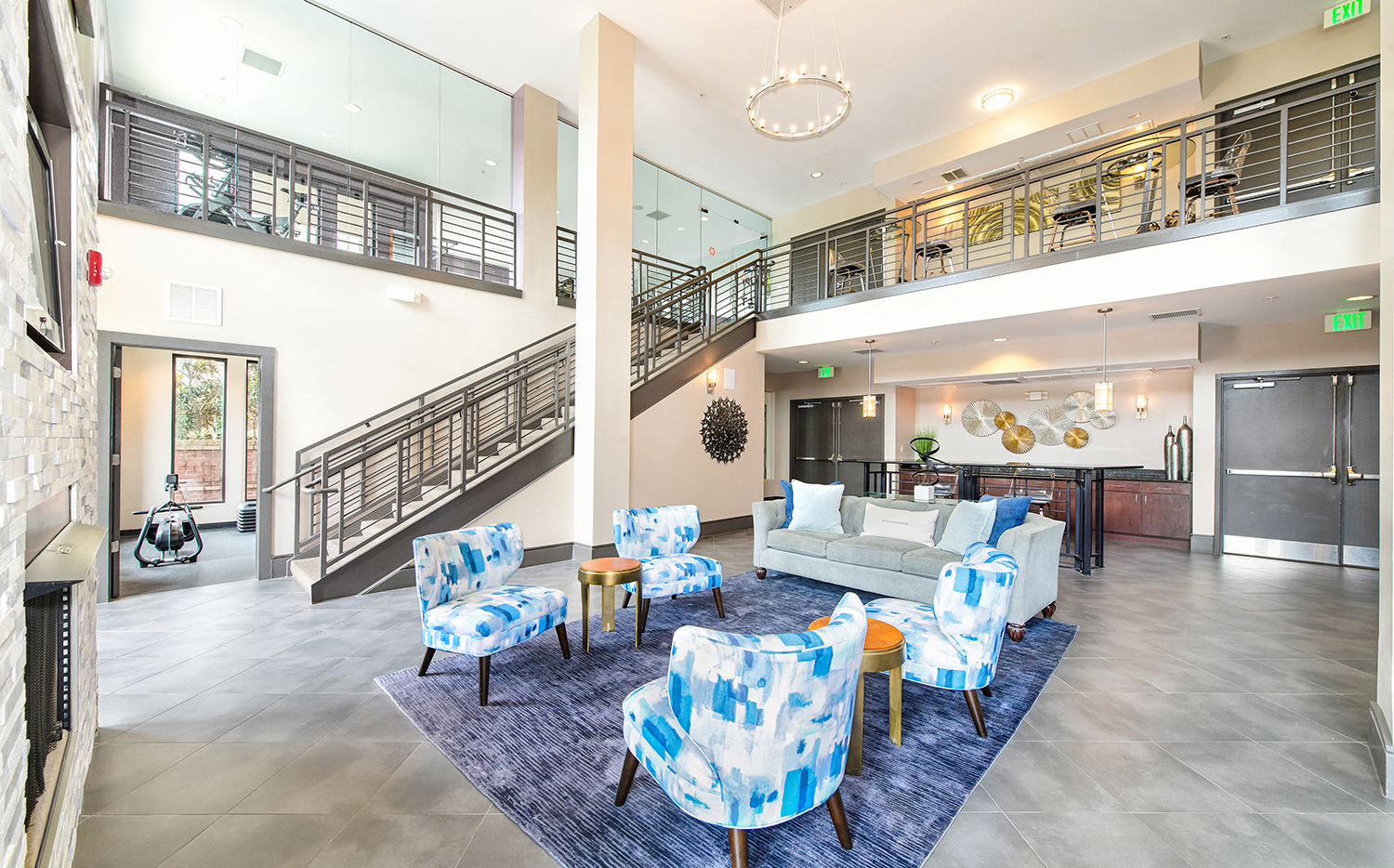 a living room with blue and white furniture and a staircase