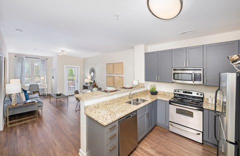 A kitchen with a granite countertop and stainless steel appliances.