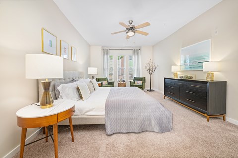 A bedroom with a bed, nightstand, and a ceiling fan.