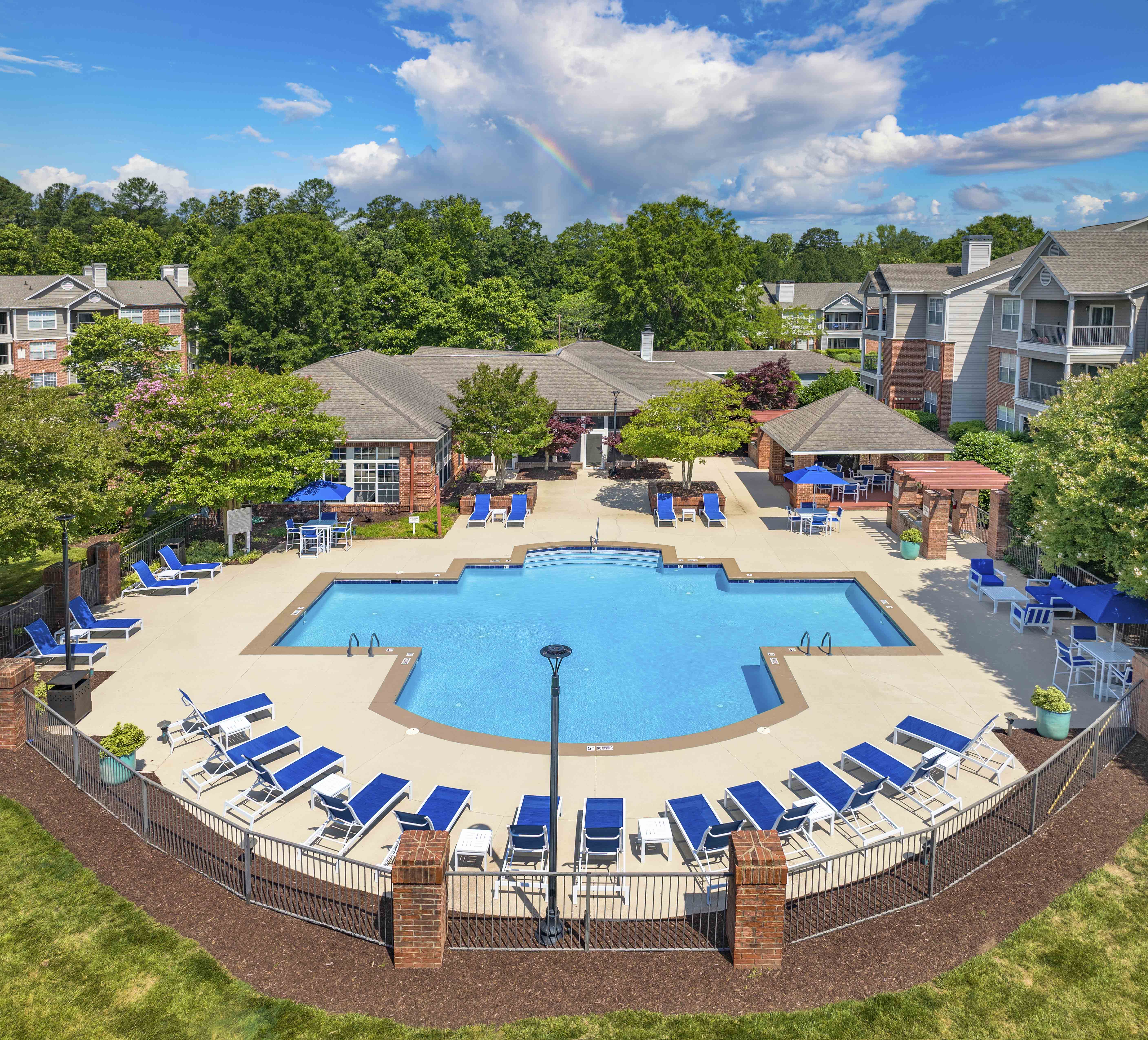 an aerial view of an outdoor pool with chairs and umbrellas