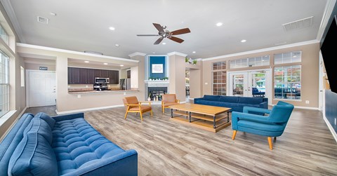 A living room with a blue couch and a fan.