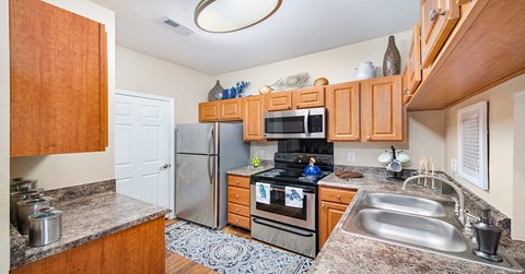 A kitchen with wooden cabinets and a refrigerator.