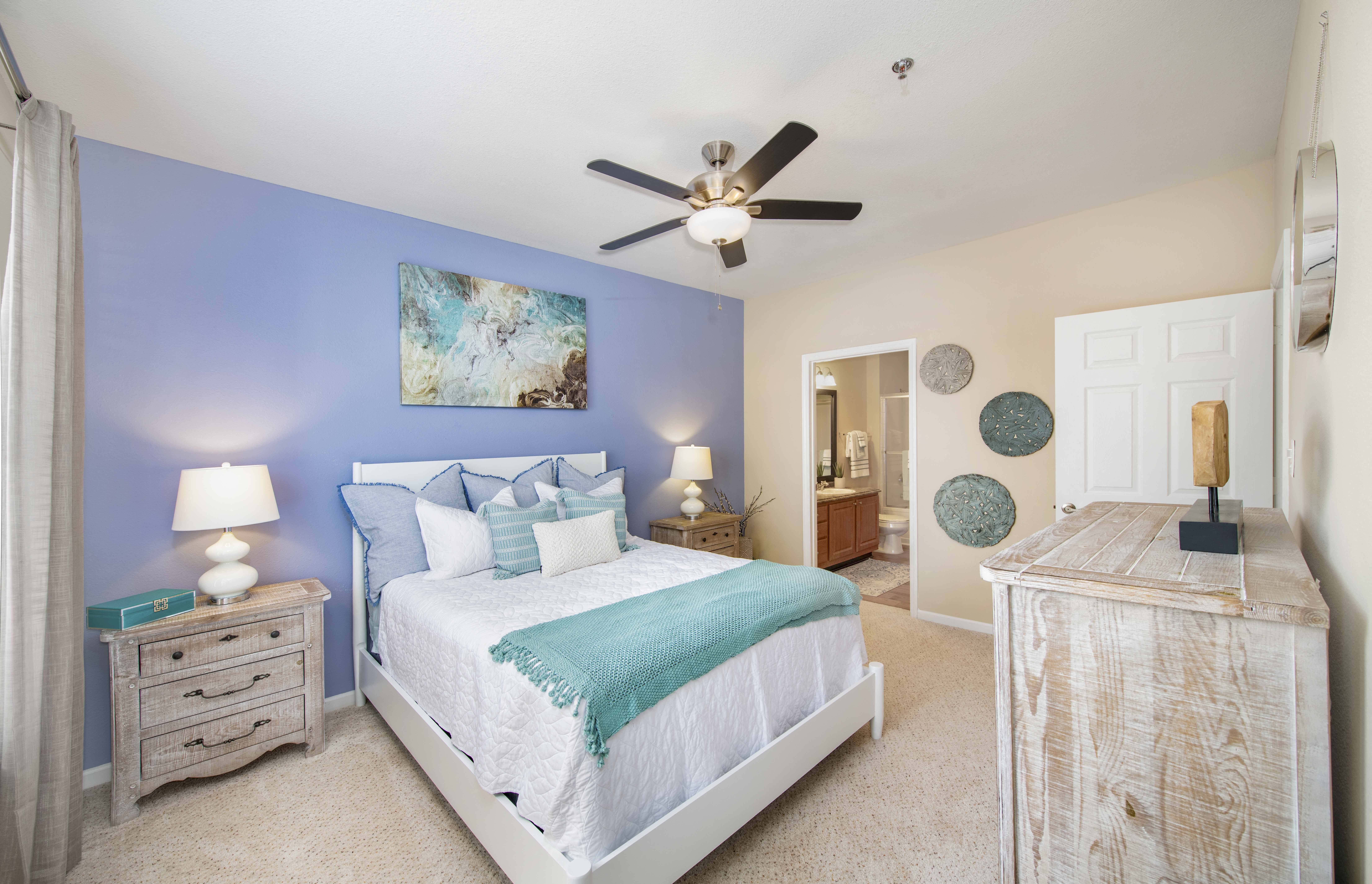 a bedroom with a bed and a ceiling fan