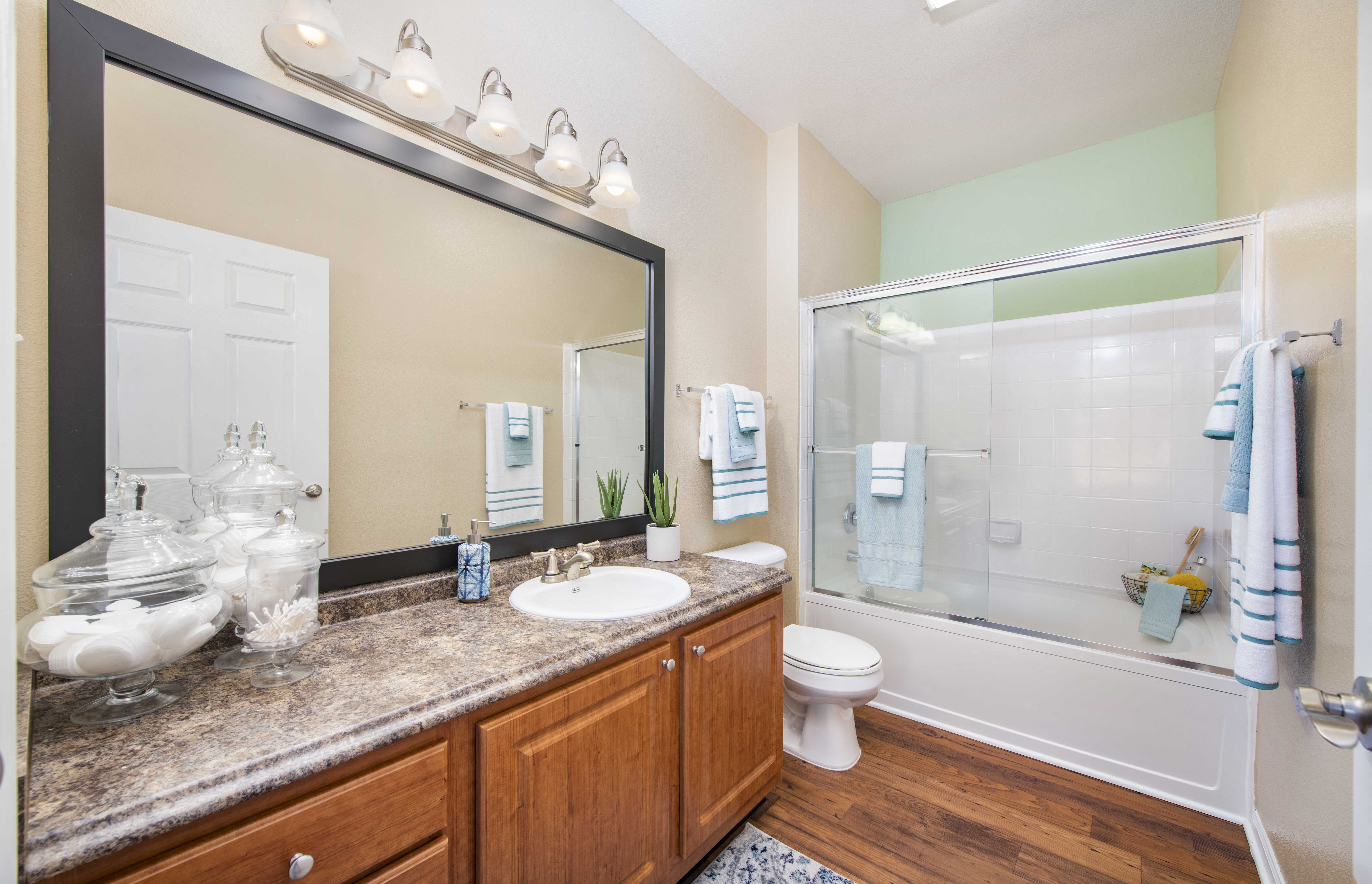 a bathroom with a large mirror and a sink and a toilet