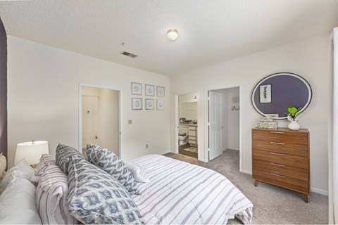 A bedroom with a bed, dresser, and mirror.