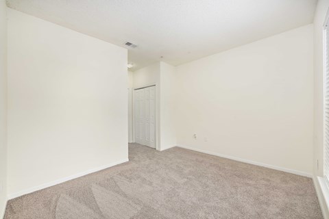 A room with a carpeted floor and a white door.
