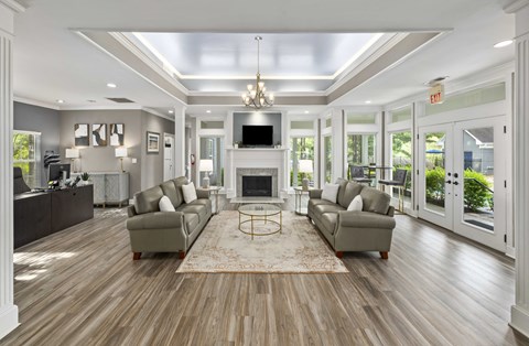 A living room with a fireplace and a rug in the middle.
