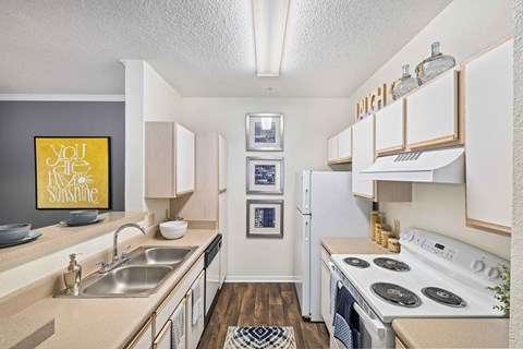 A kitchen with a stove top oven and a fridge.