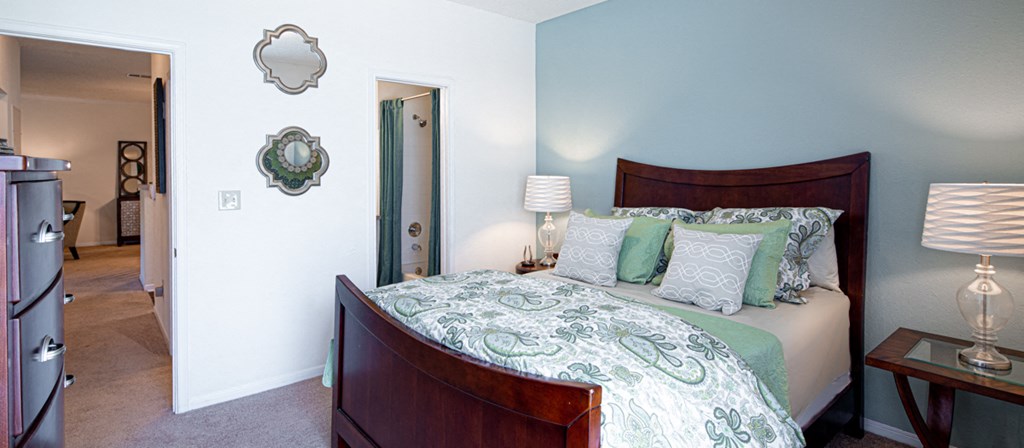 a bedroom with a bed and a door to a bathroom