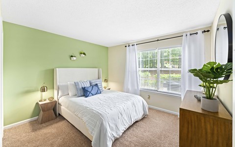 a bedroom with a bed and a large window