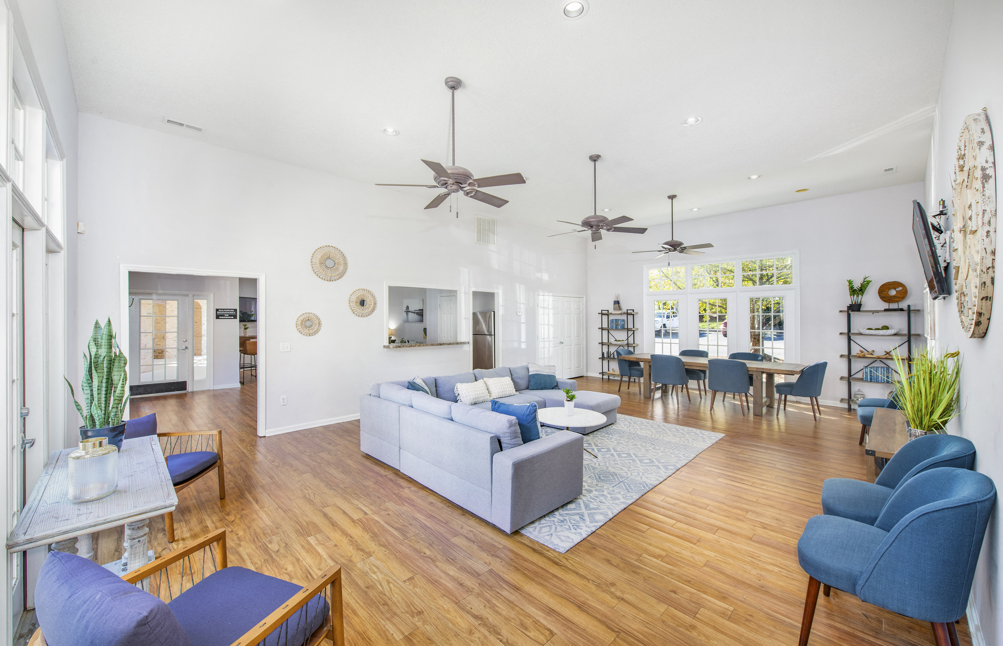 the living room and dining room of a house with blue chairs and couches
