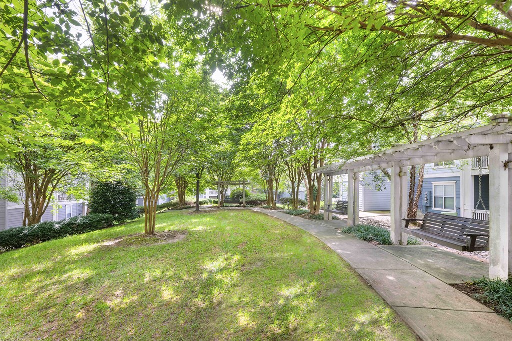 A tree-lined walkway leads to a building.