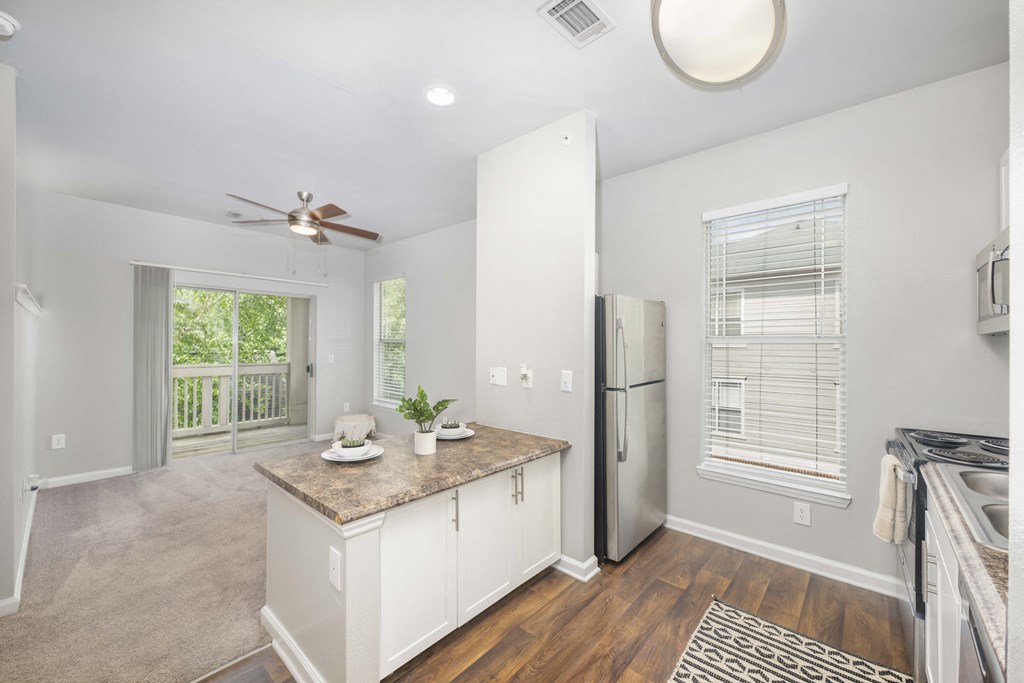 A kitchen with a refrigerator, sink, and countertop.