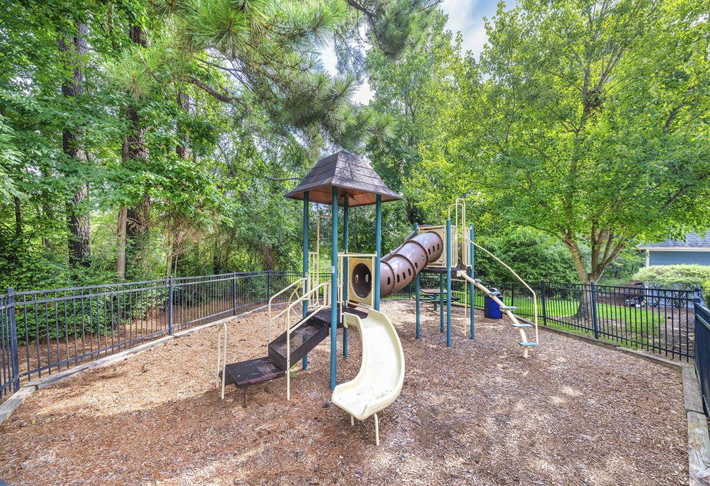 A playground with a slide, a wooden structure, and a climbing frame.
