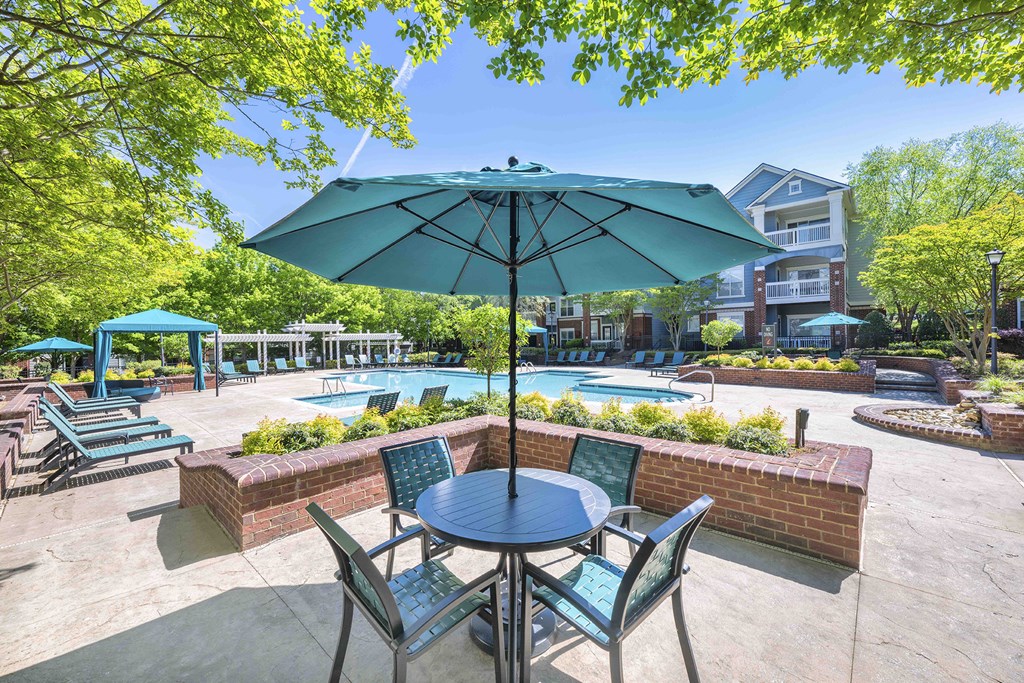 A patio with a table and chairs and an umbrella over it.