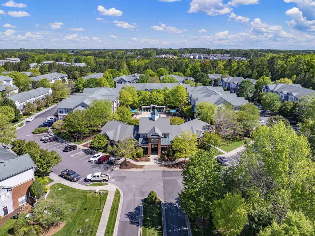A bird's eye view of a residential area with houses and parked cars.