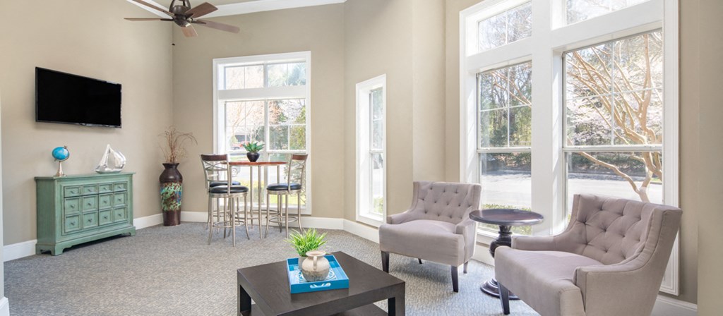 a living room with chairs and a table and a tv