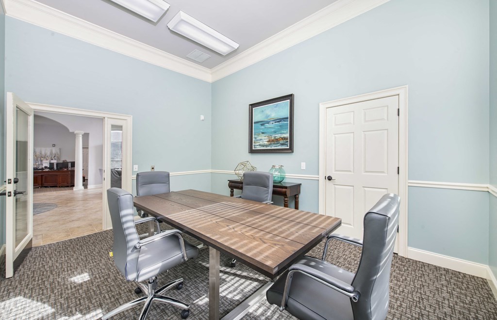 a conference room with blue walls and a wooden table and chairs