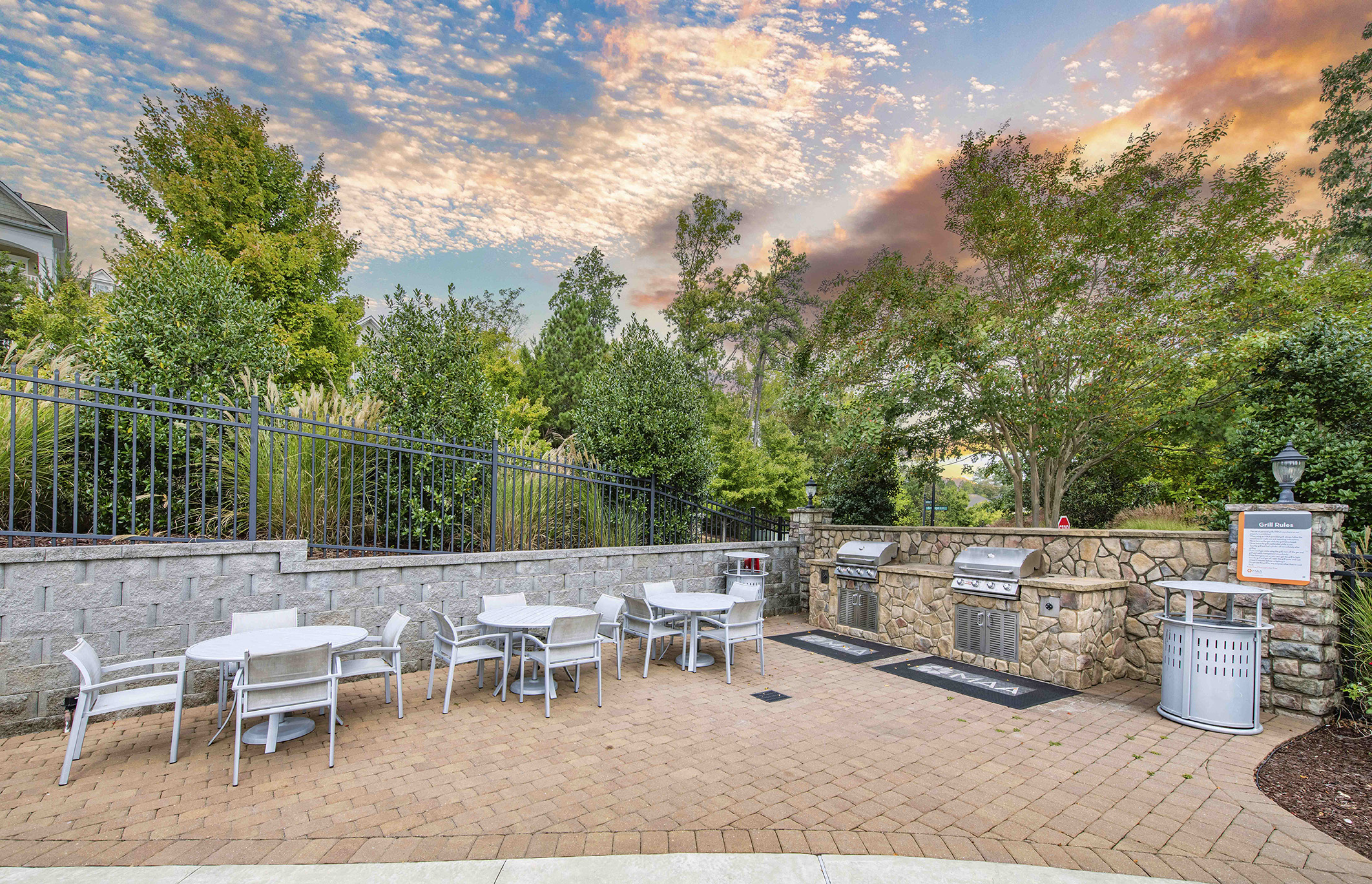 a patio with tables and chairs and a stone wall