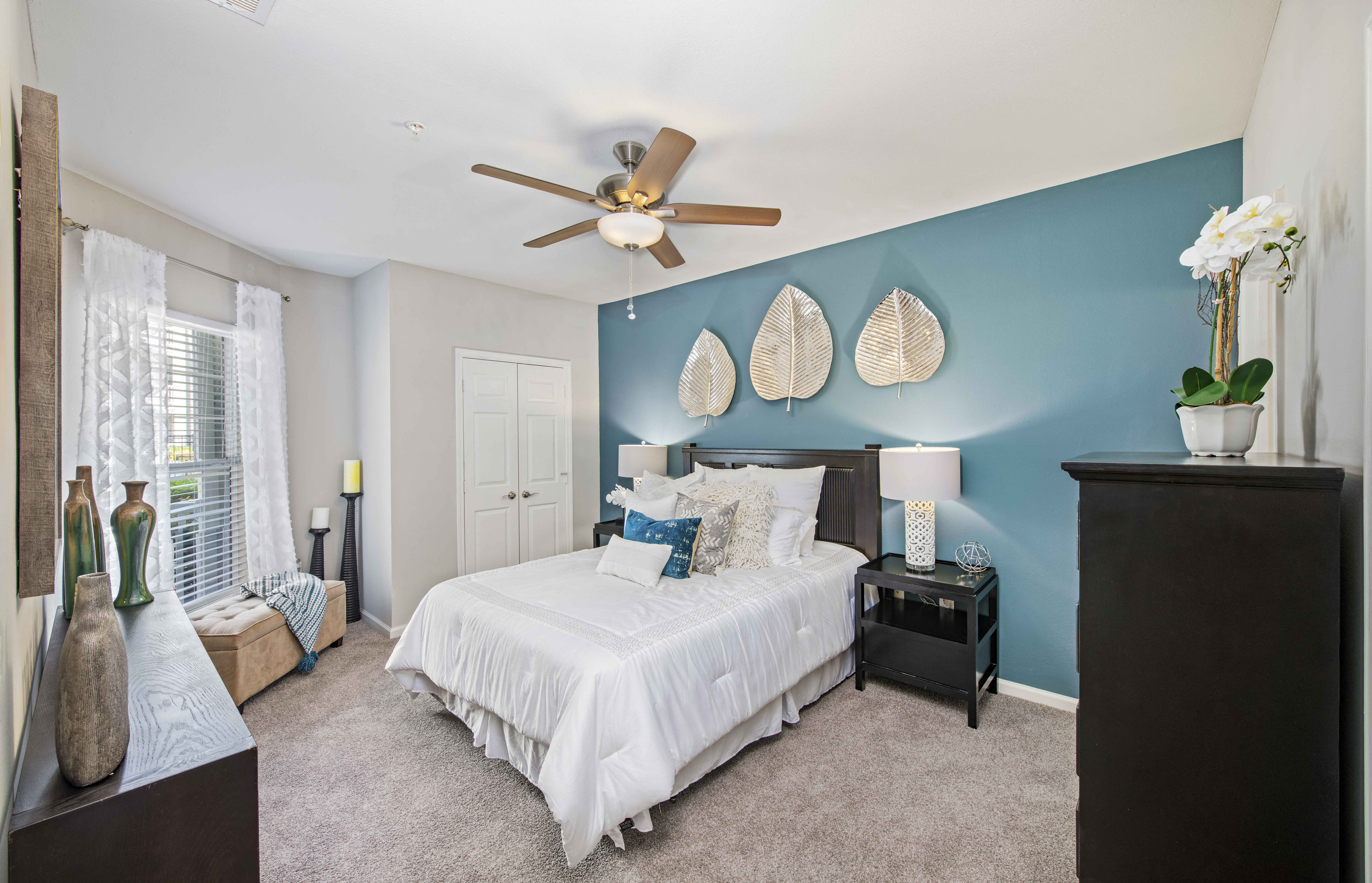 a bedroom with a bed and a ceiling fan