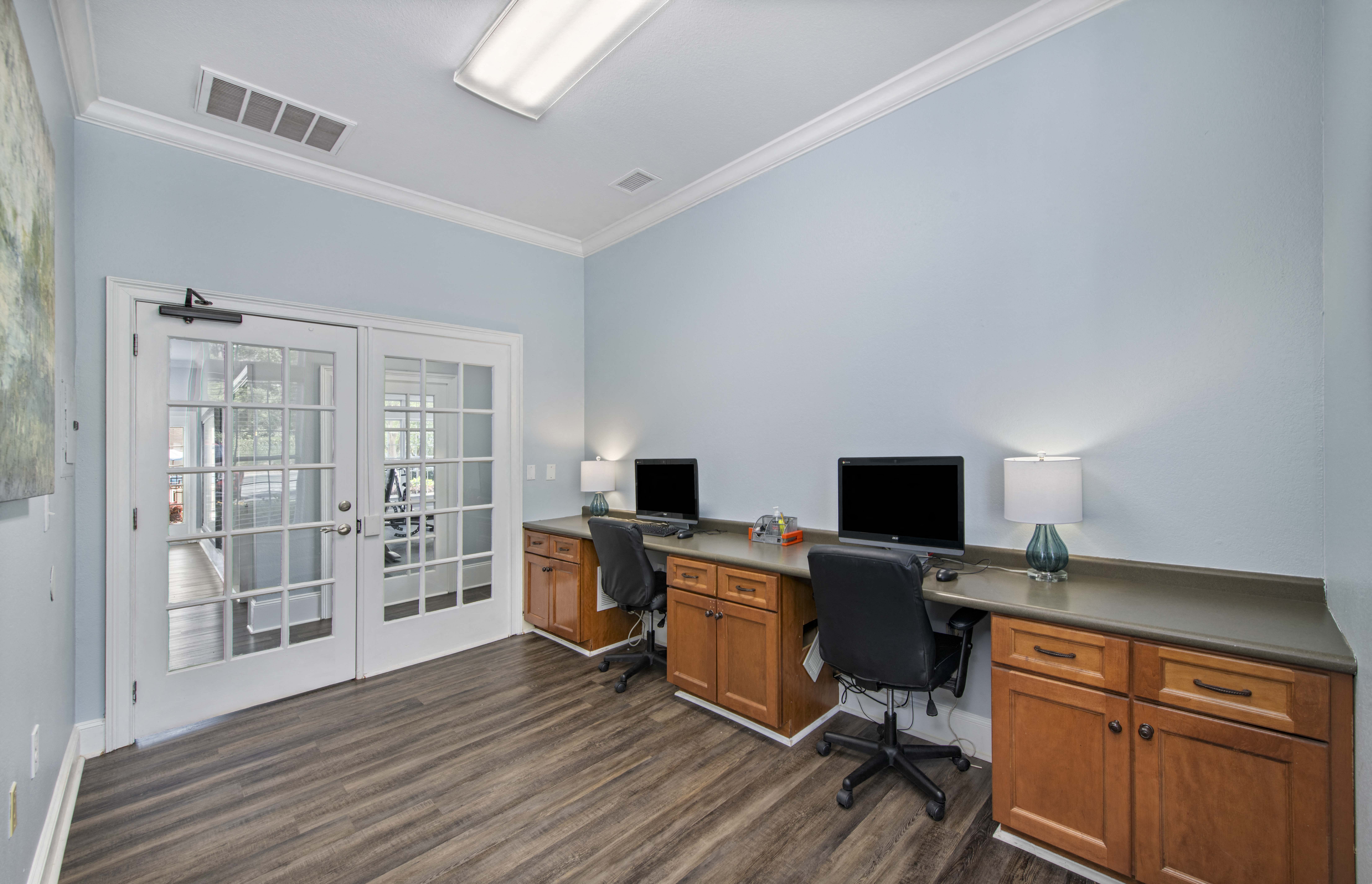 a home office with two desks and two computer monitors