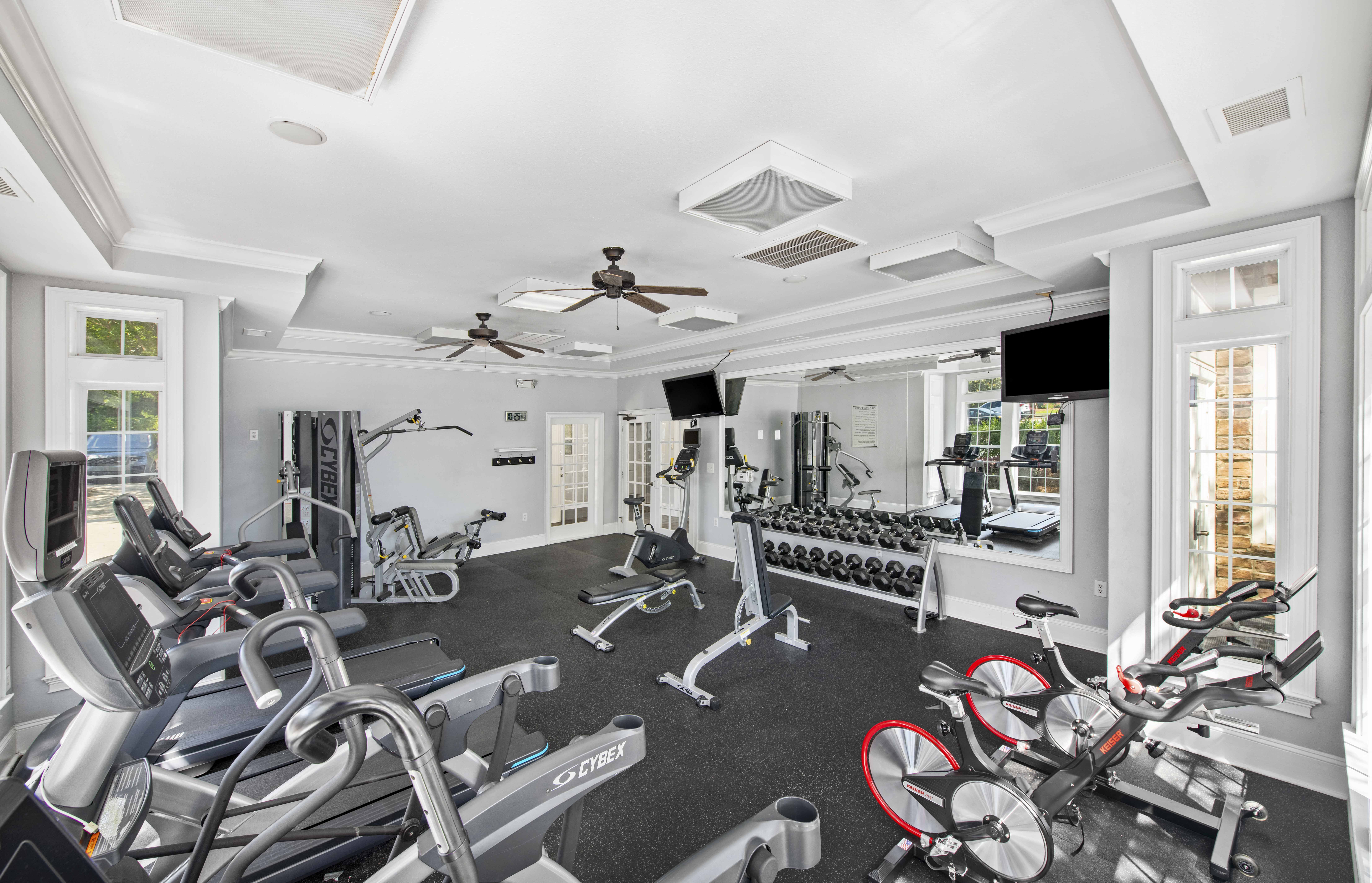 a gym with a lot of exercise equipment and windows