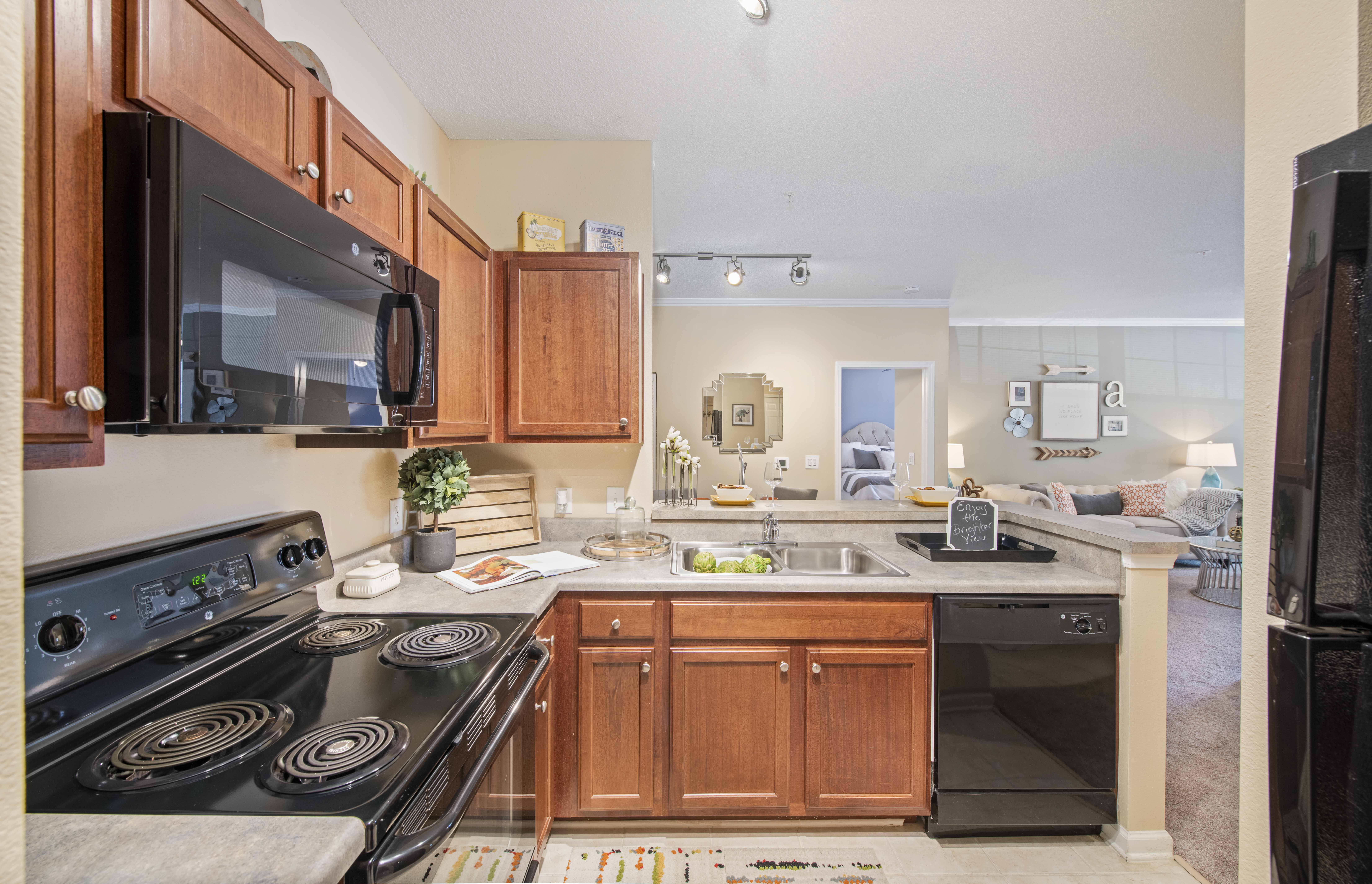 a kitchen with black appliances and wooden cabinets