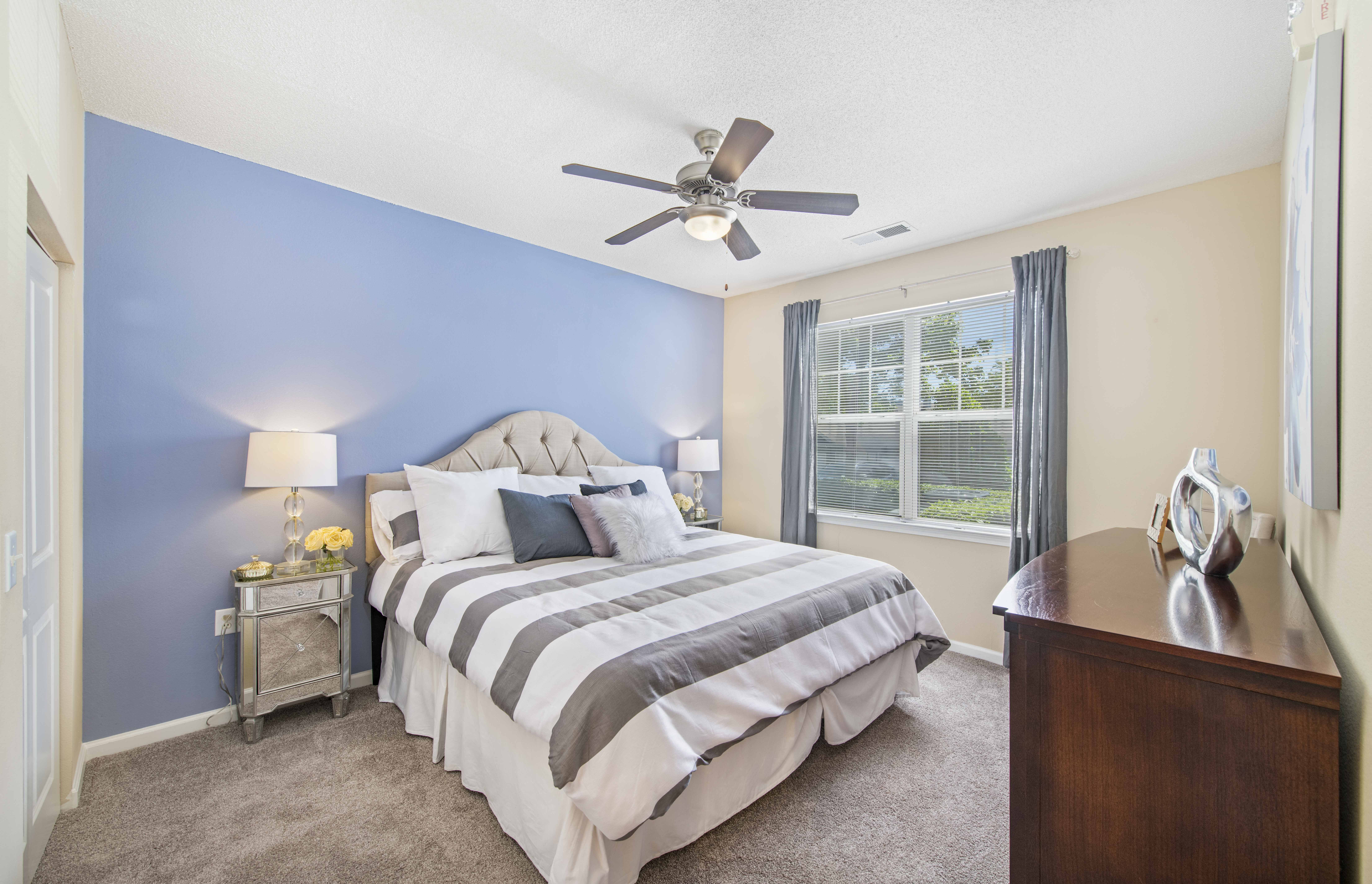 a bedroom with a bed and a ceiling fan
