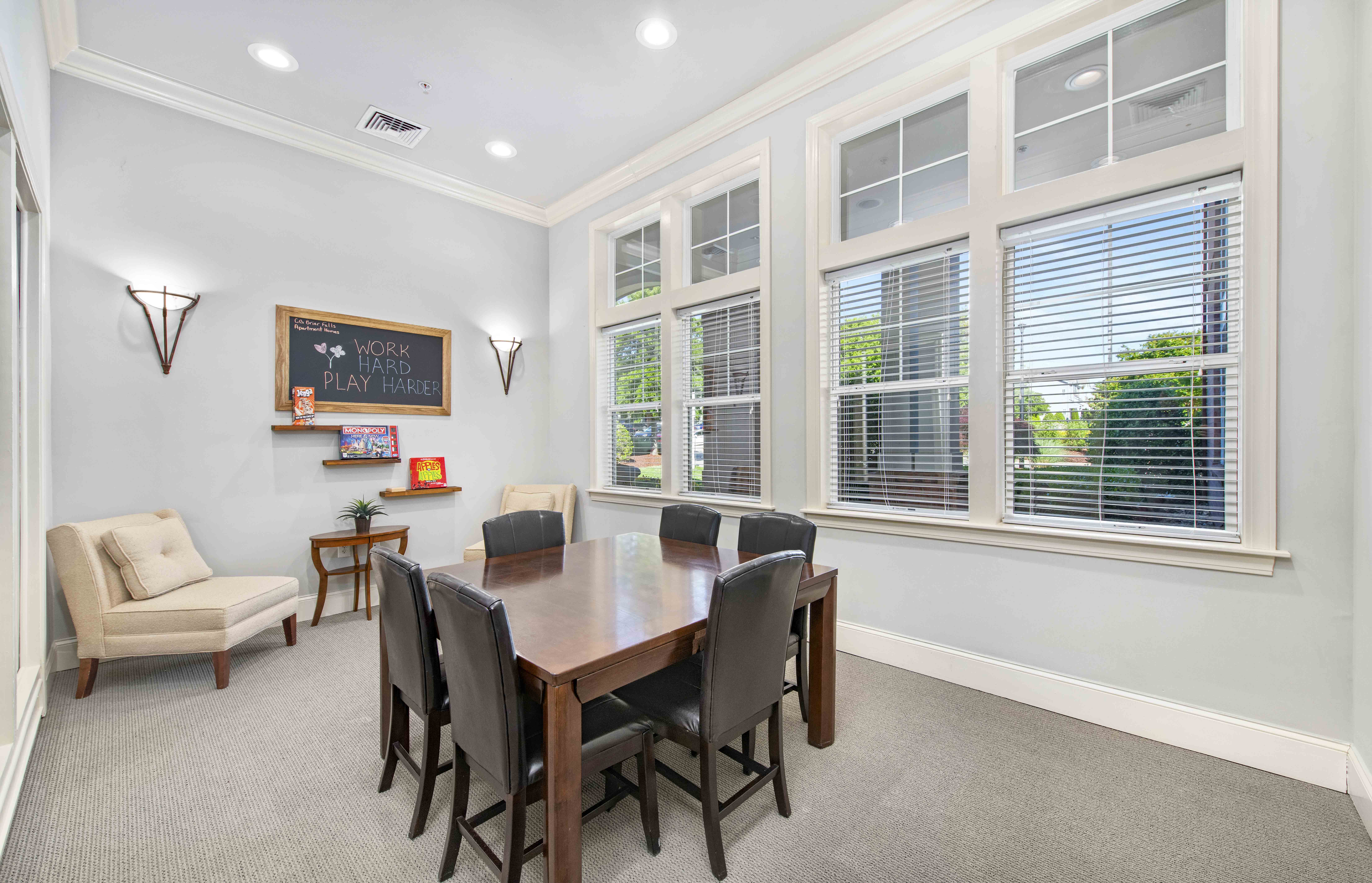 a dining room with a table and chairs in front of windows