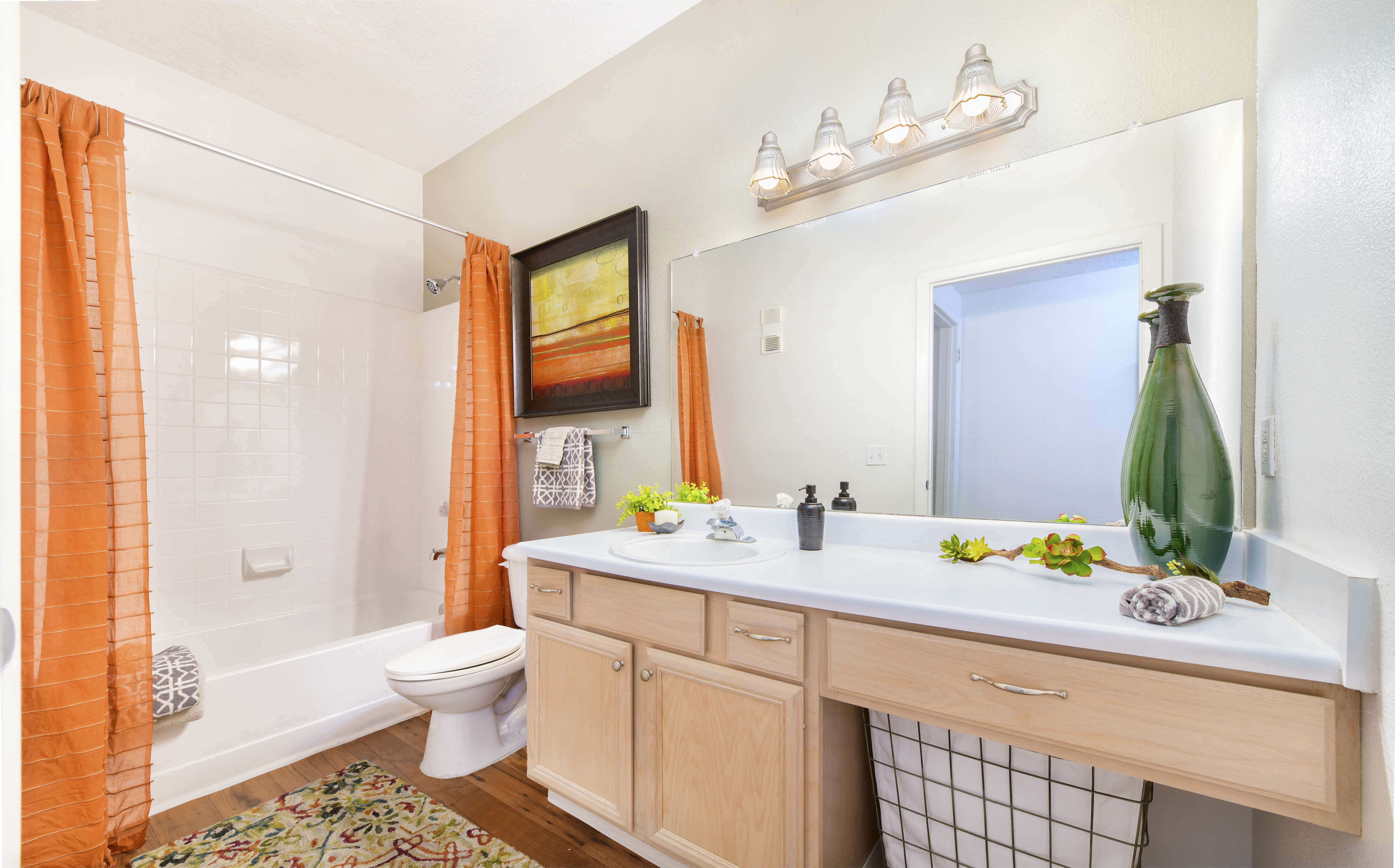 a bathroom with a large mirror and a sink and a toilet
