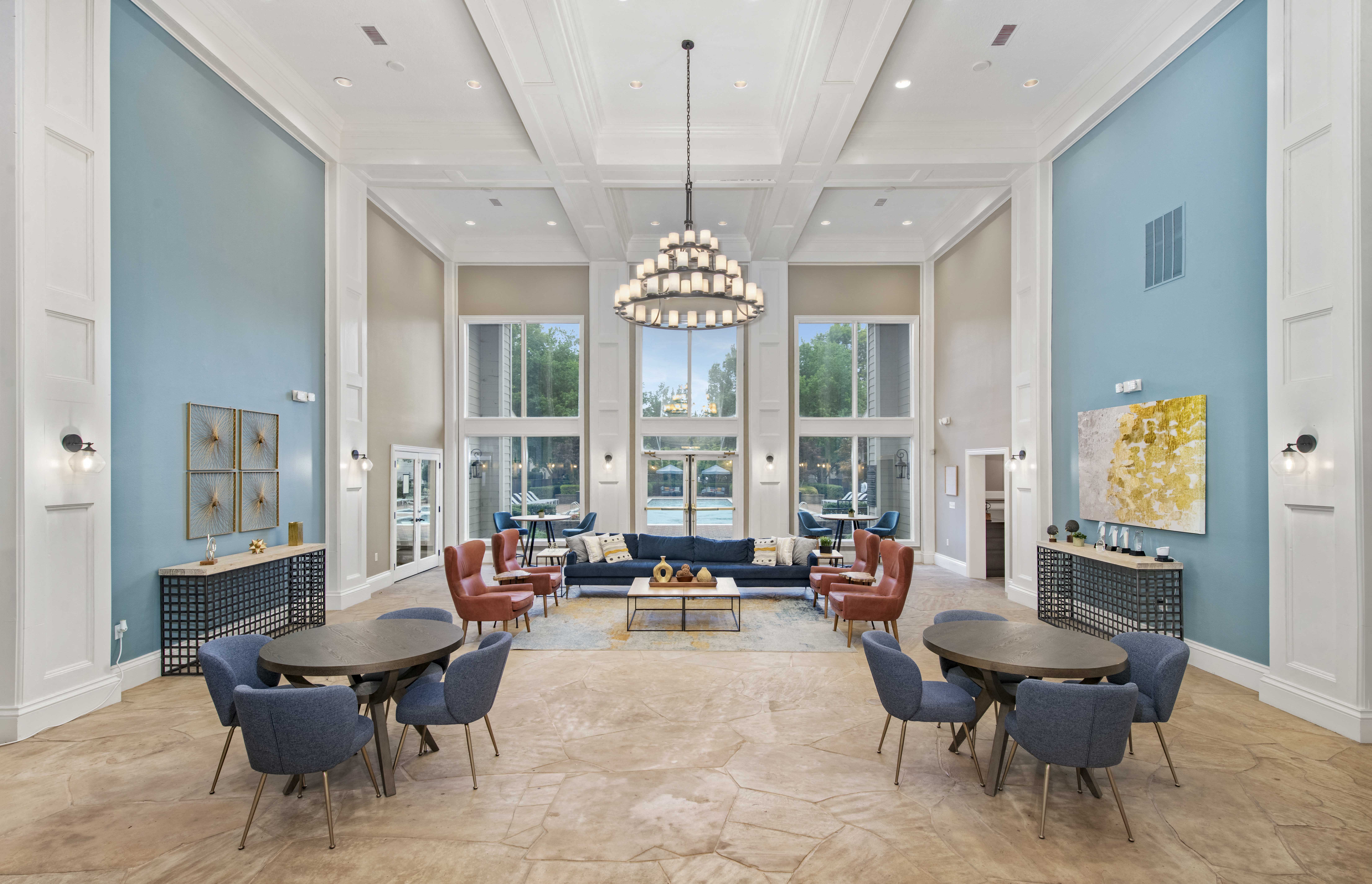 a large living room with blue walls and a large chandelier
