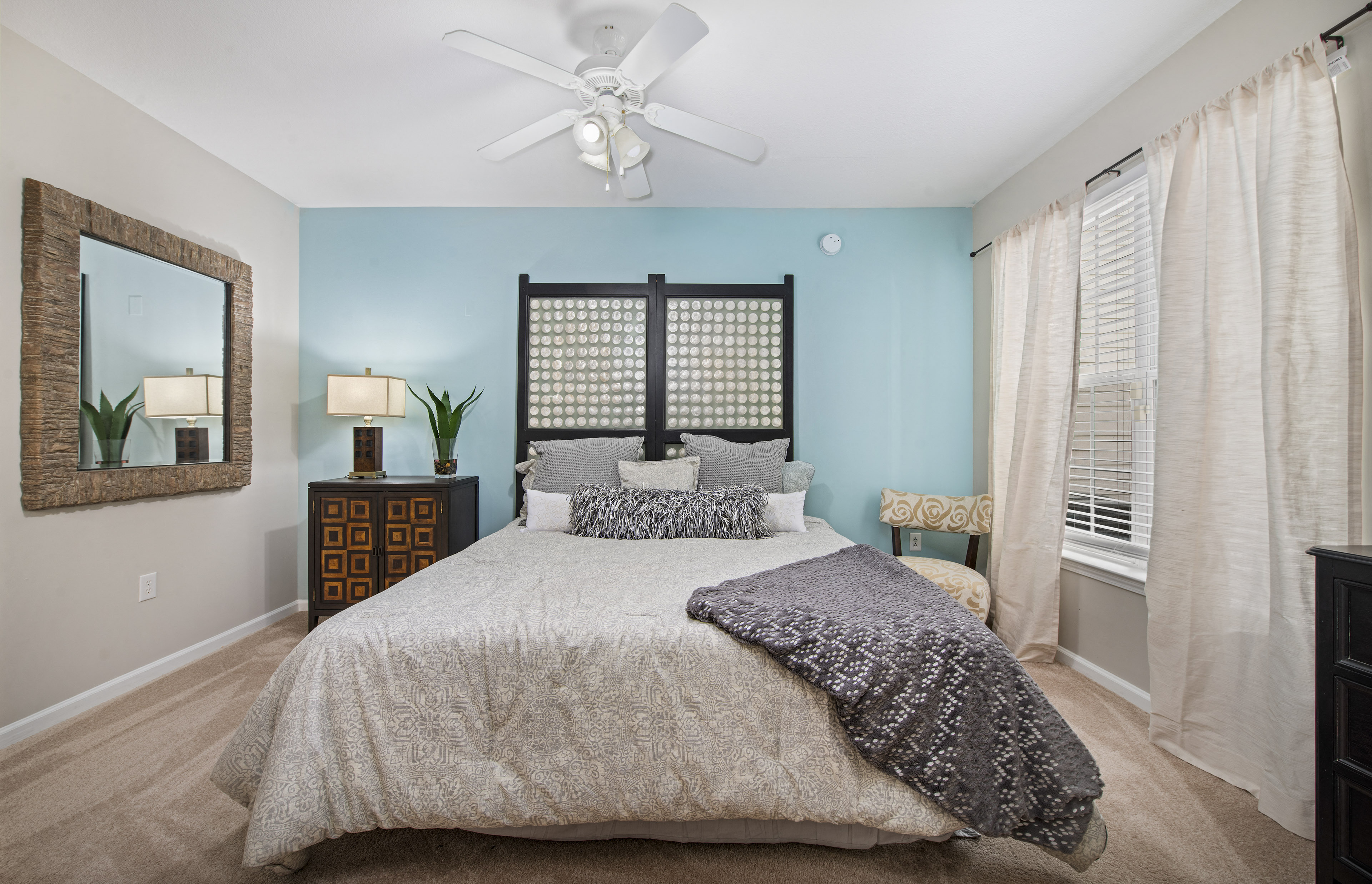 a bedroom with a bed and a ceiling fan