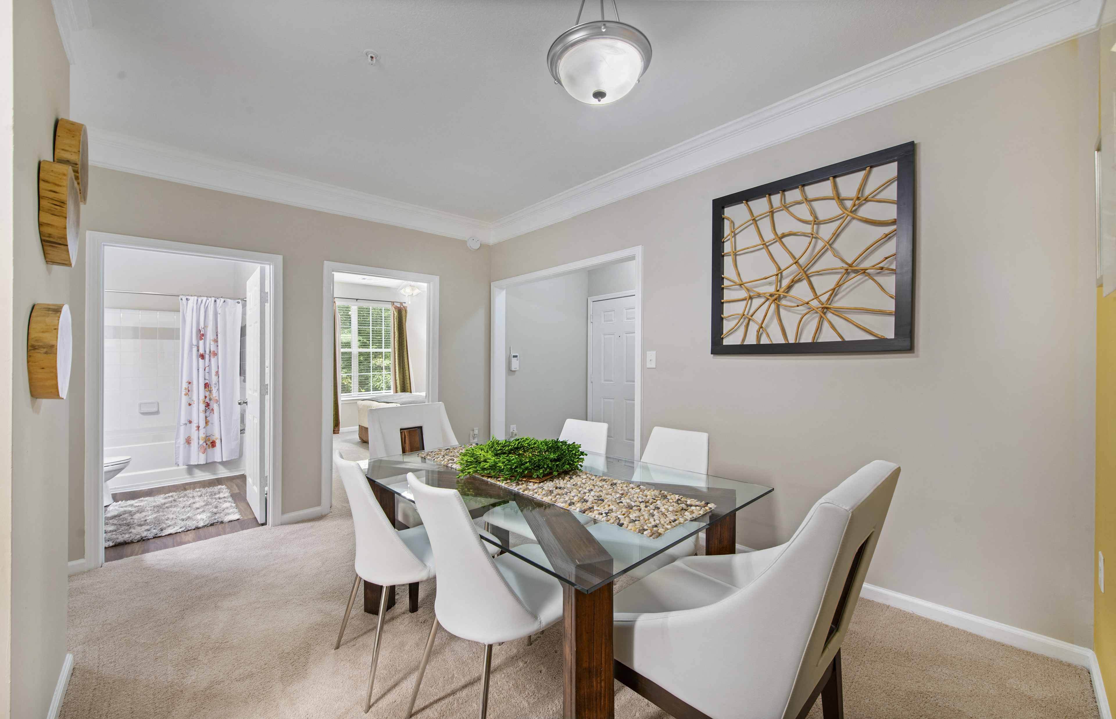 a dining room with a glass table and white chairs