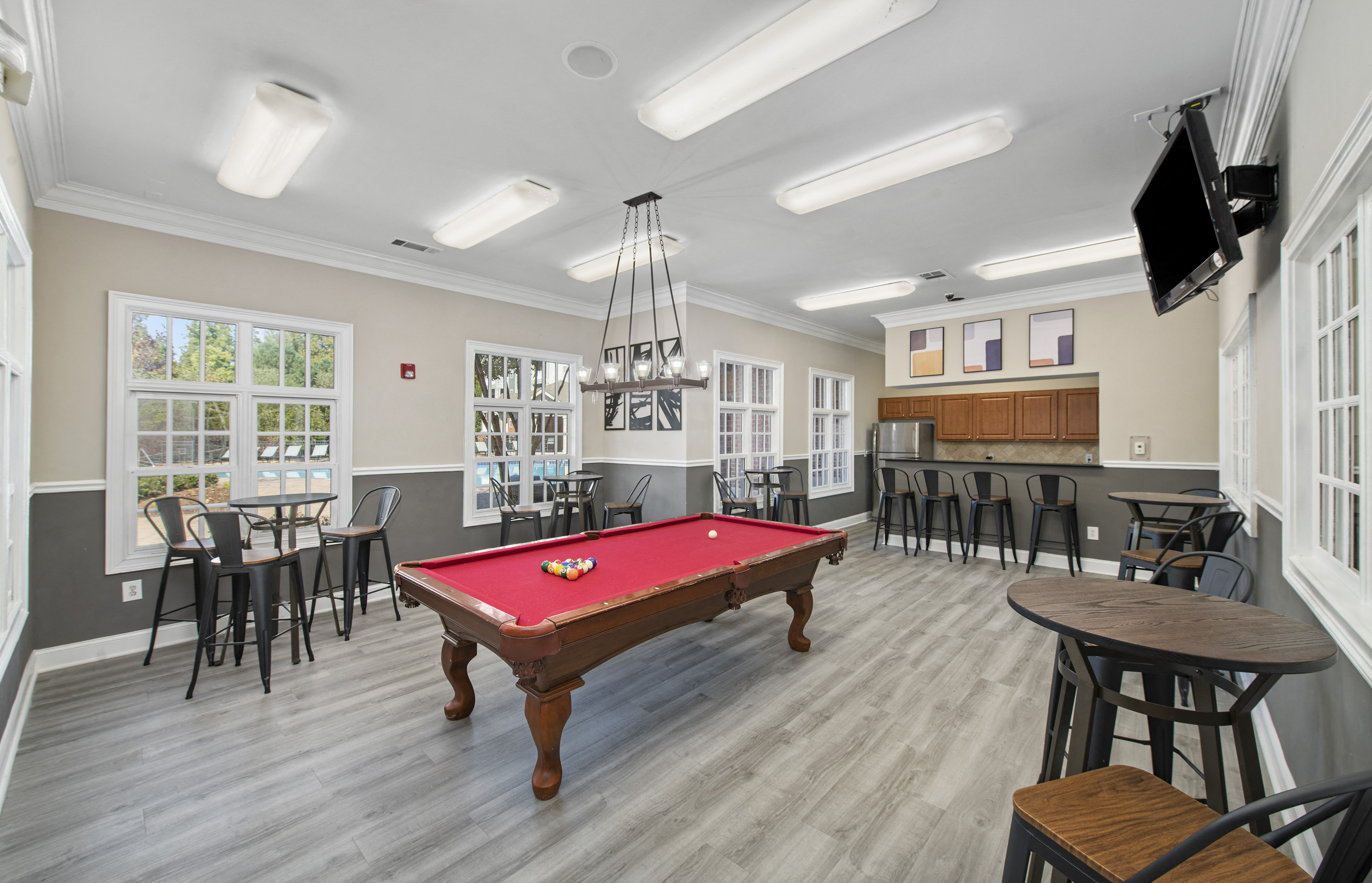 a community room with a pool table and a tv