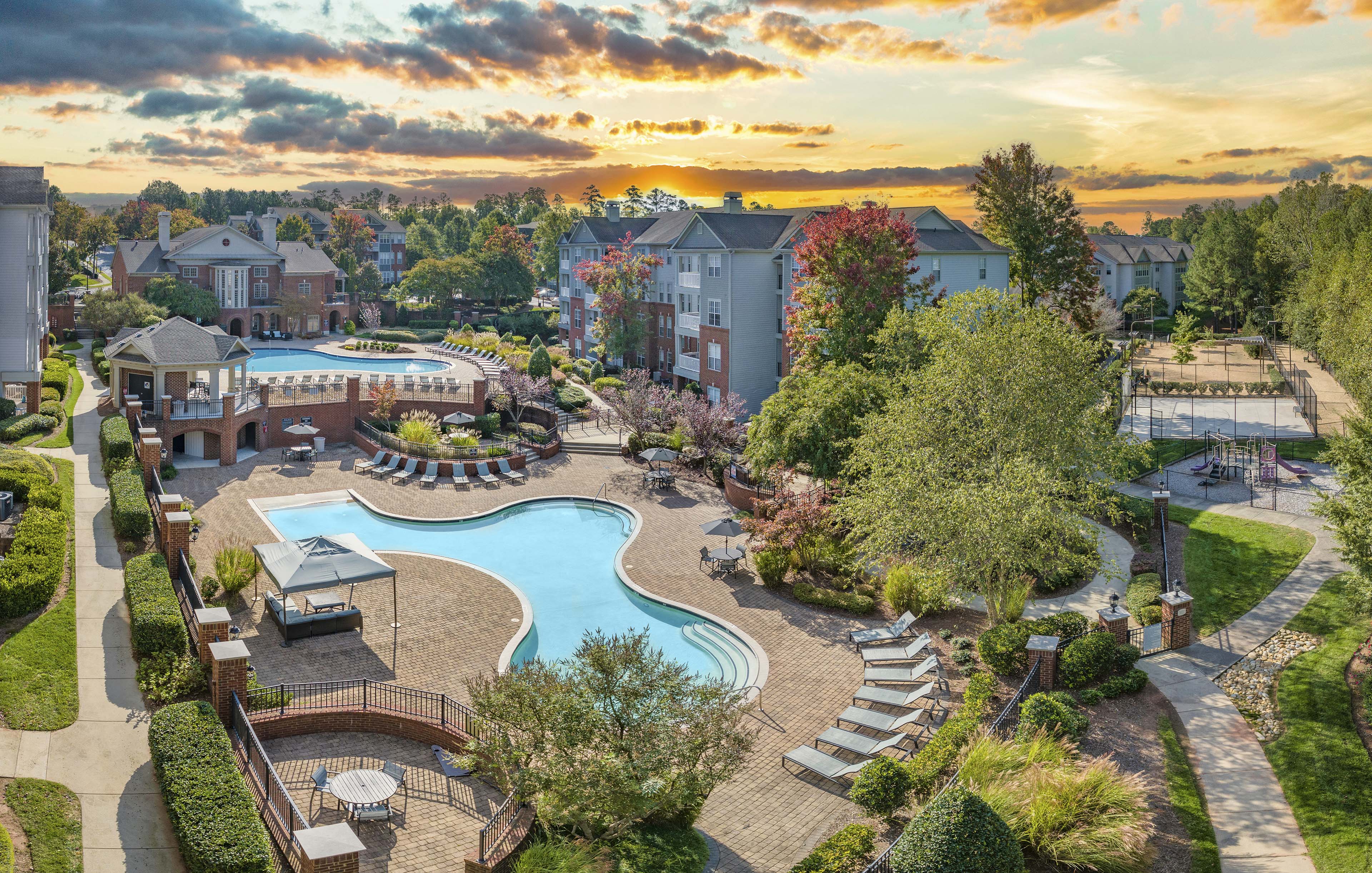 an aerial view of a swimming pool at a resort with buildings